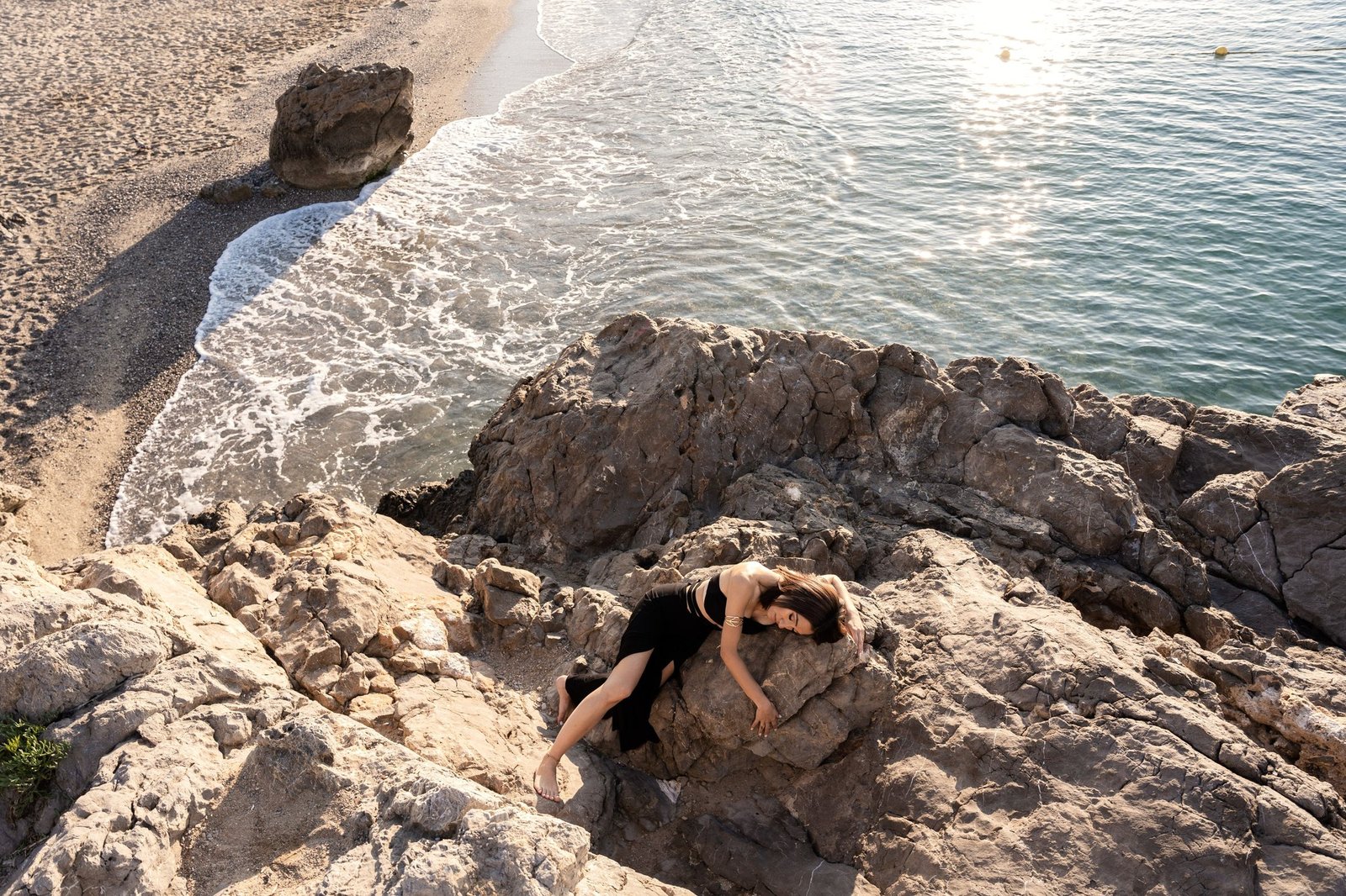 Mona Hassan on the rocks above the sea